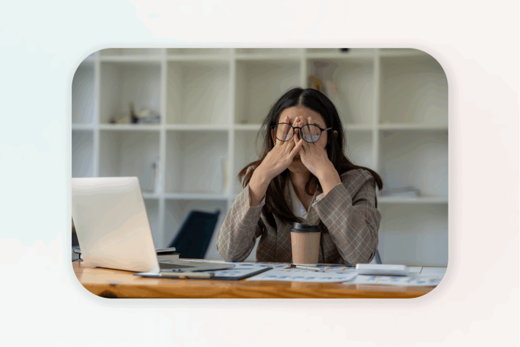 Woman feeling stressed at desk with laptop.