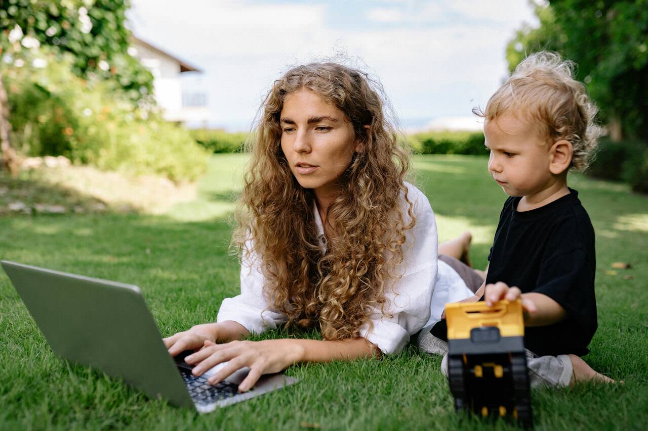 Mompreneur successfully managing work and family life with laptop and child