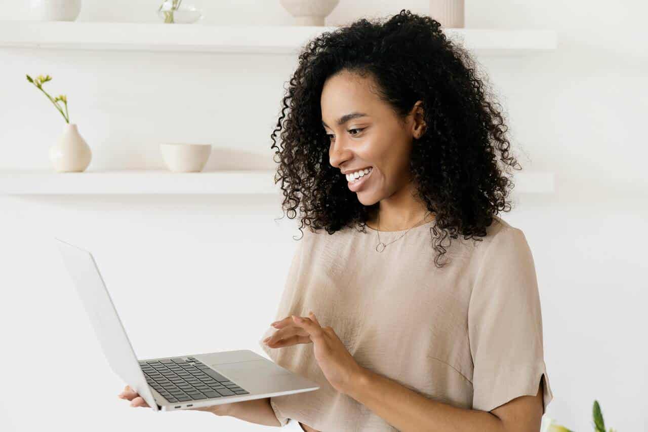Happy woman entrepreneur working on laptop - successful mompreneur