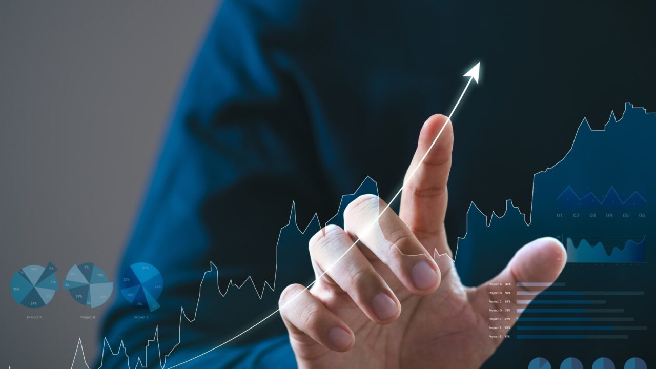 Businessman pointing at upward arrow graph showing growth