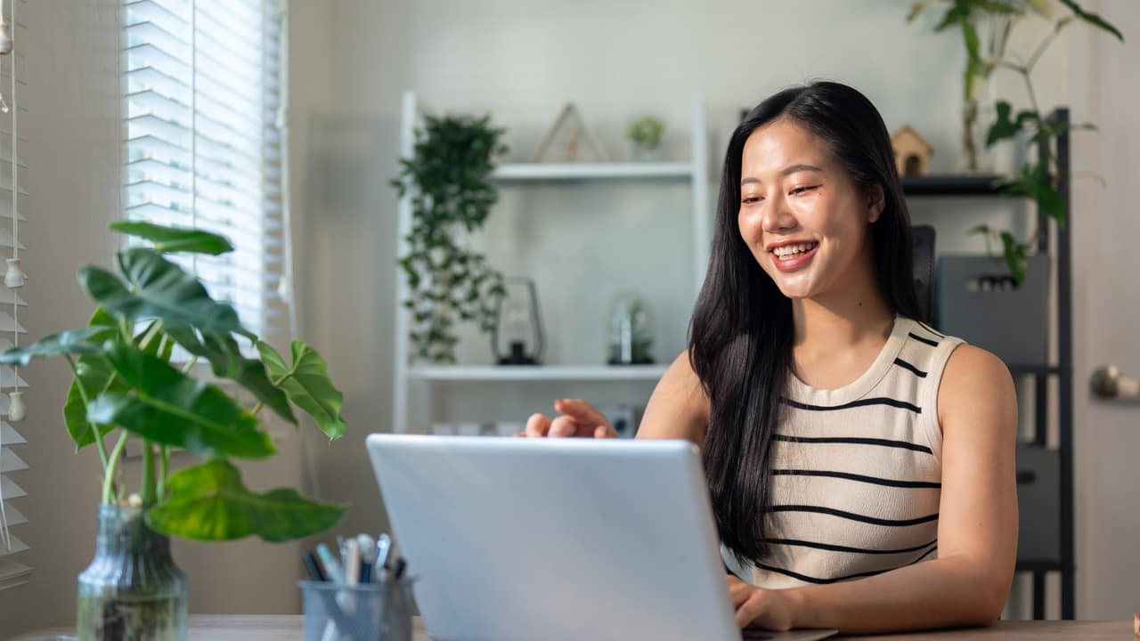 Girl smiling with her laptop working on online business