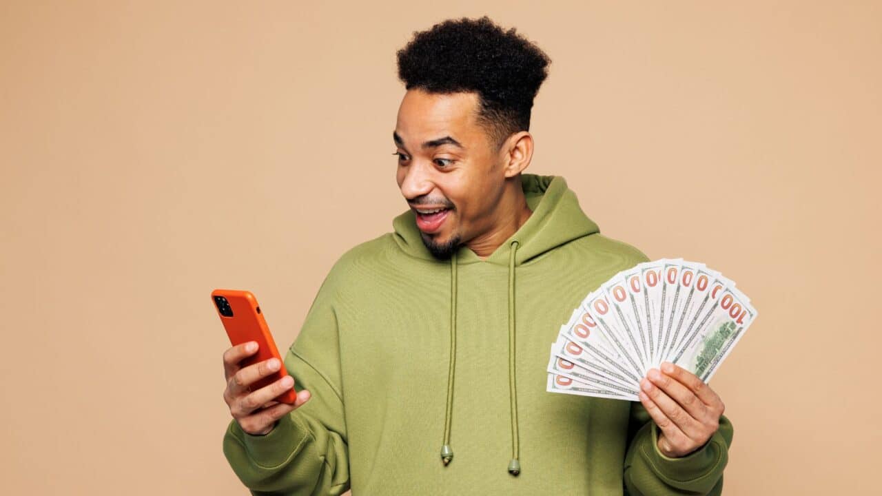 12_excited_man_holding_cash_and_phone