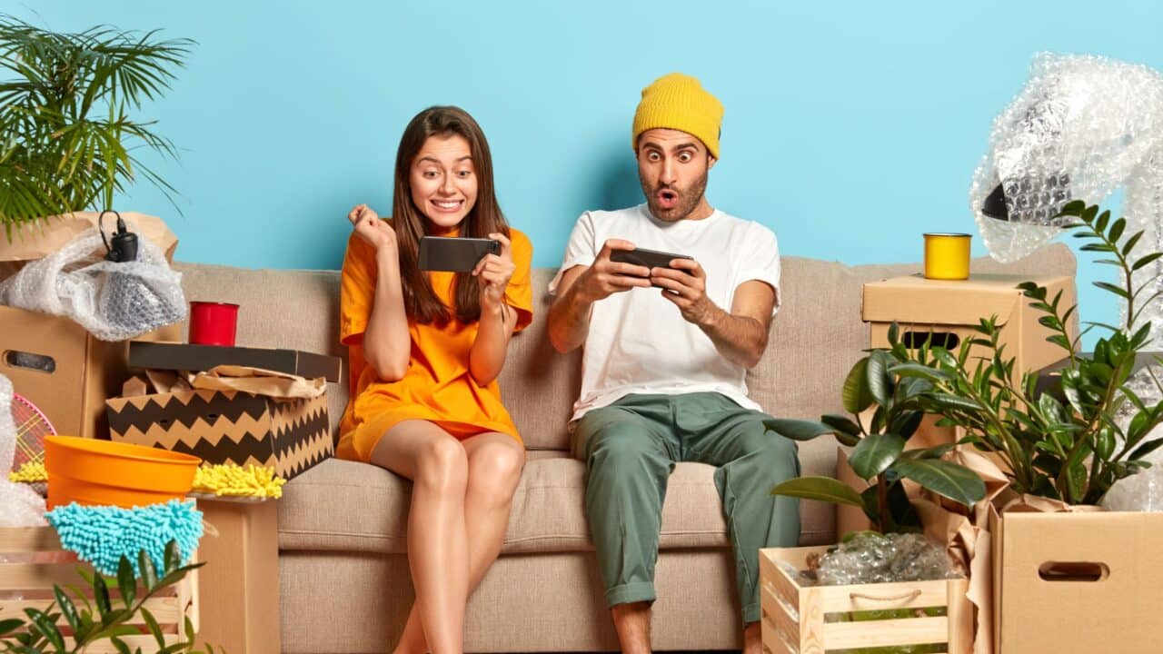 3_addicted_teenagers_playing_mobile_games_amid_moving_boxes