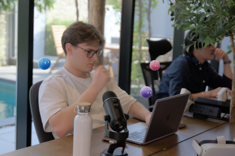 Professional reviewing work on a laptop with colorful Nas AI agents nearby.